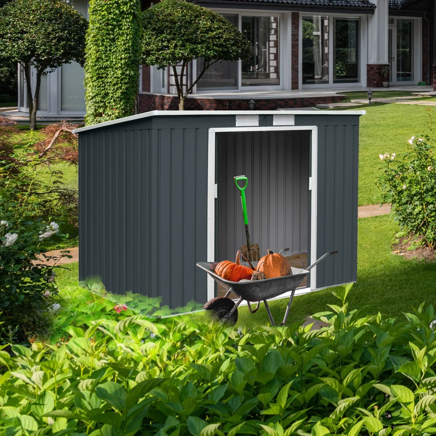 Dunkelgraues Hattoro P100 Metall Gerätehaus mit Pultdach und Schubkarre mit Gartengeräten im Garten.