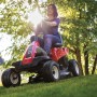 Roter Troy-Bilt Aufsitzmäher Mini-Rider 76T-S mit Seitenauswurf beim Rasenmähen.