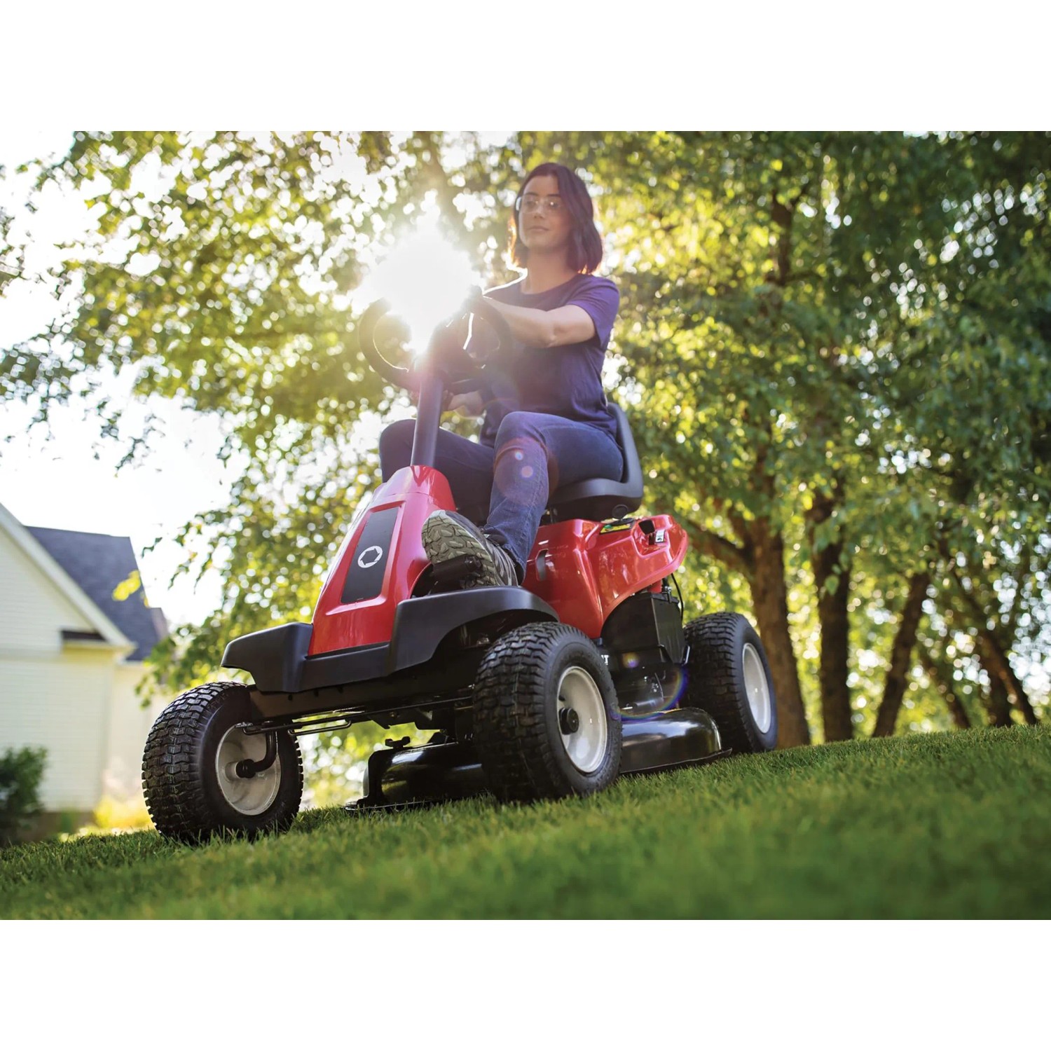 Roter Troy-Bilt Aufsitzmäher Mini-Rider 76T-S mit Seitenauswurf beim Rasenmähen.