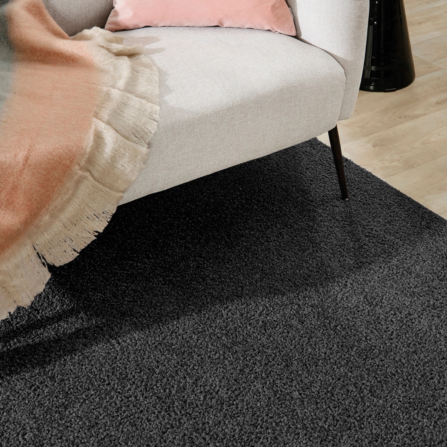 Anthrazitfarbener Kurzflor Teppich (115x170 cm) neben einem Sessel. Klassischer Stil.