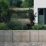 Graue Mauerscheibe aus Beton (105x100x65cm) zur Böschungsbefestigung im Garten.