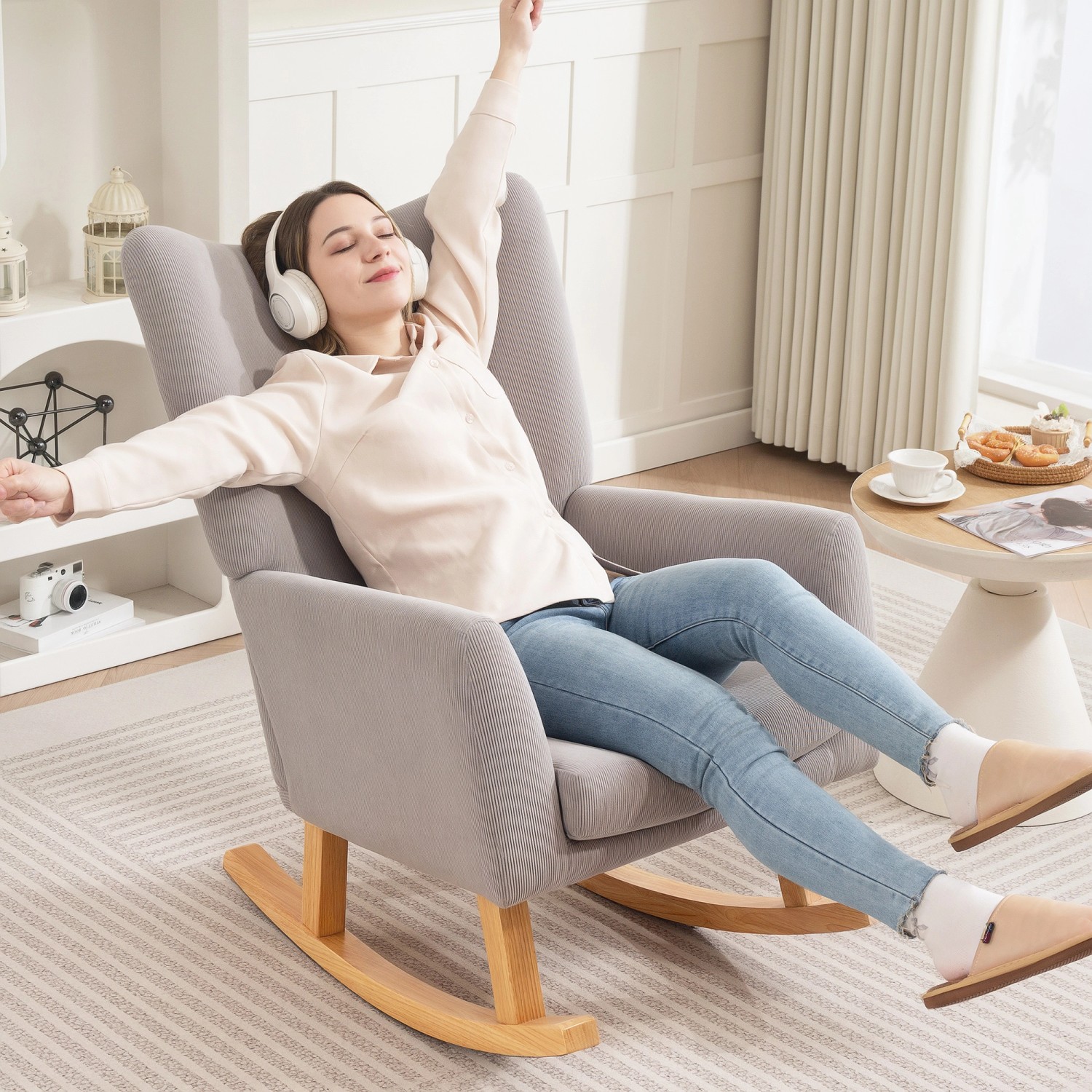 Frau entspannt im hellgrauen HOMCOM Schaukelstuhl aus Polyester und Holz.