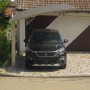 Moderner Ximax Carport Portoforte-80 mit gebogenem Polycarbonat-Dach und Edelstahl-Look Aluminiumpfosten, schützt Auto.