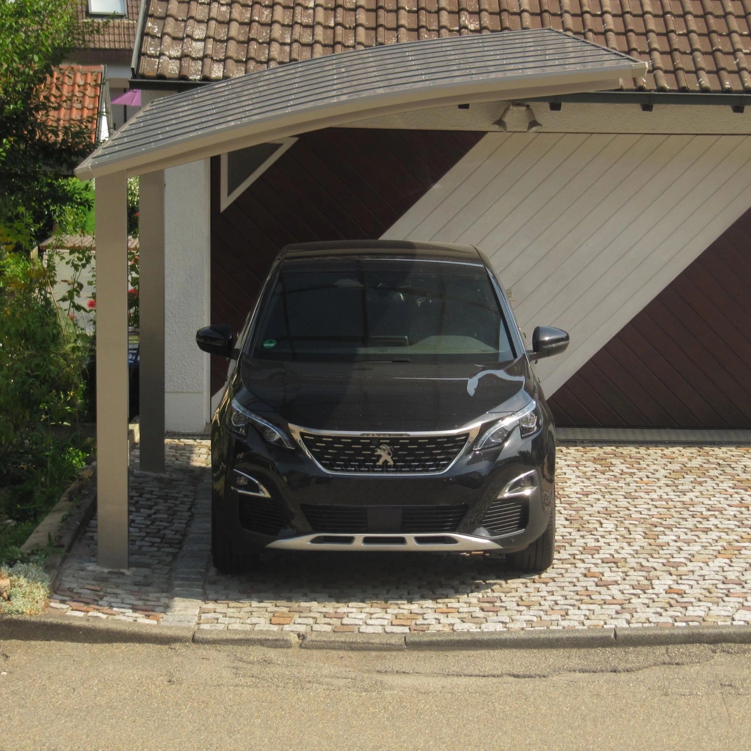 Moderner Ximax Carport Portoforte-80 mit gebogenem Polycarbonat-Dach und Edelstahl-Look Aluminiumpfosten, schützt Auto.