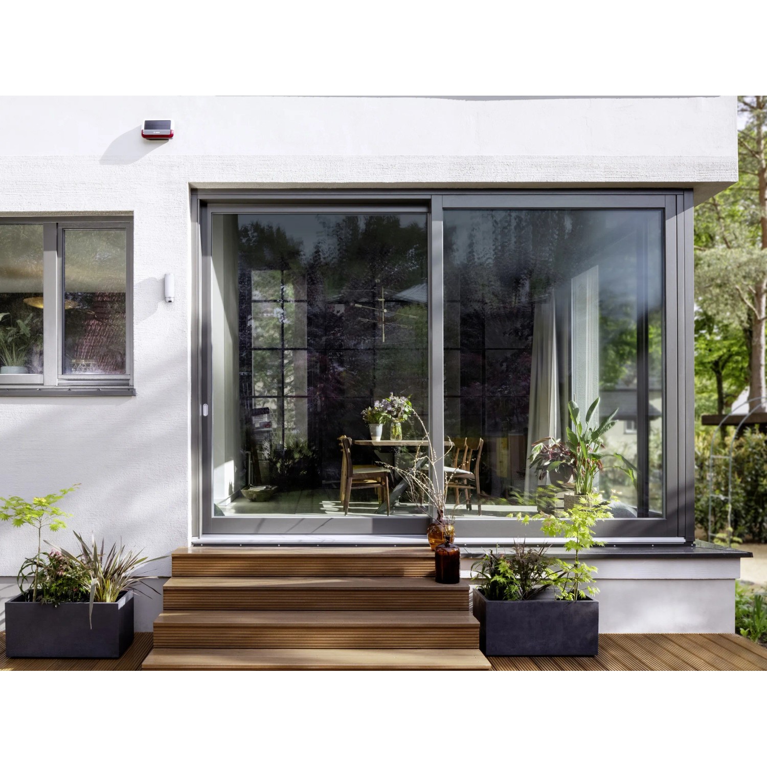 Bosch Smart Home Außensirene am Haus montiert. Smarte Alarmanlage mit Solarpanel.