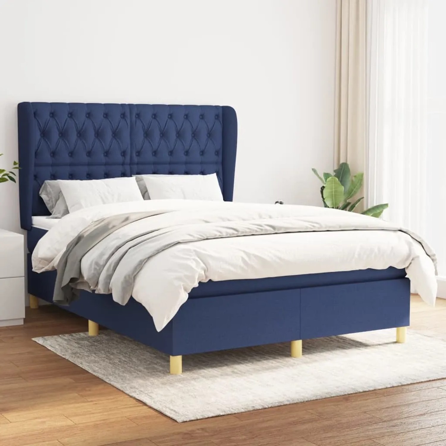 Blaues Boxspringbett (140x190 cm) mit Matratze und Stoffbezug. Bequemes Bett mit hohem Kopfteil.