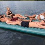 Bestway Hydro Force Floating Platform Sun Soaker mit vier Personen auf dem Wasser.