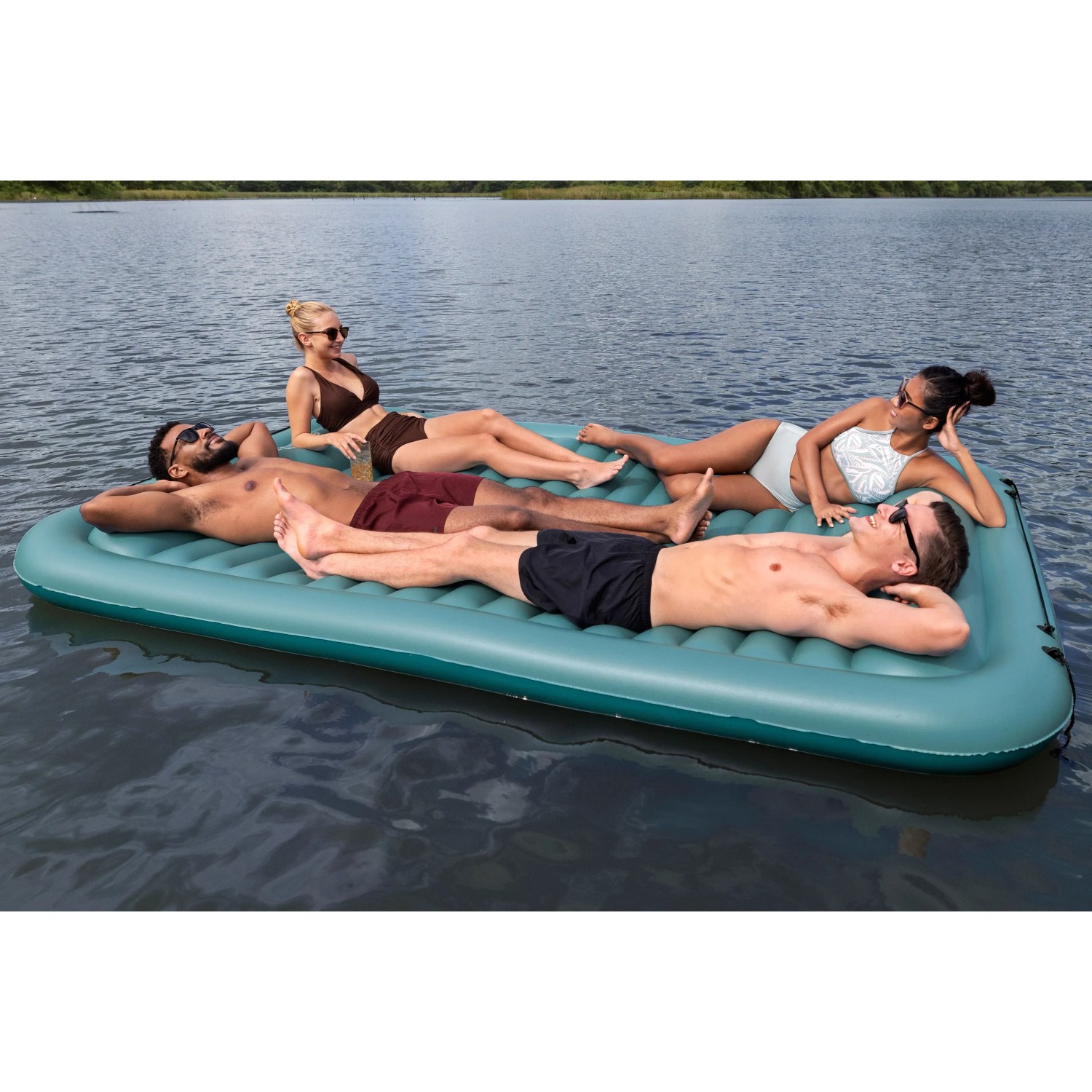 Bestway Hydro Force Floating Platform Sun Soaker mit vier Personen auf dem Wasser.