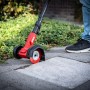 Skil Akku-Fugenreiniger im Einsatz auf Pflastersteinen, rote Bürste, Akku-Gartengerät.
