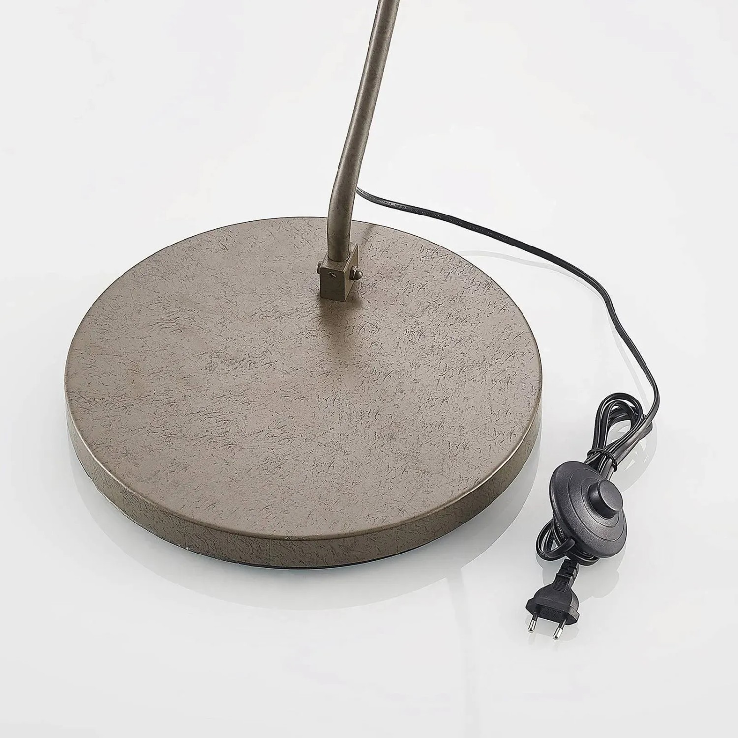 Detailaufnahme der Lindby Bogenleuchte Jonera: Fuß, Kabel und Fußschalter der Stehlampe in Alu.