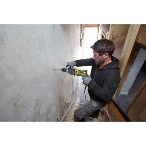 Mann bohrt mit Stanley FatMax Schlagbohrmaschine FMEH1100K in Wand. Inkl. Tiefenanschlag.