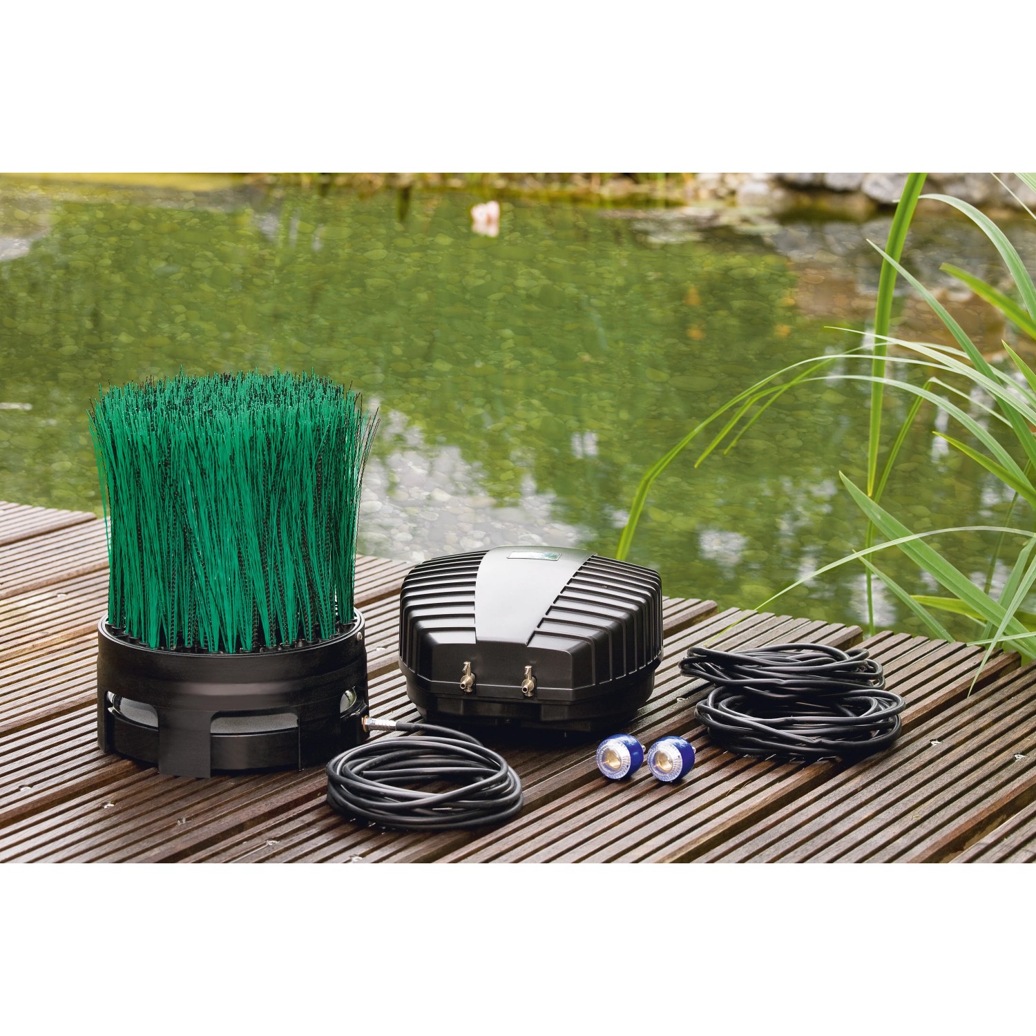 Oase OxyTex Set 1000 Teichbelüfter mit Filtermedium und Zubehör auf Holzsteg vor Teich.