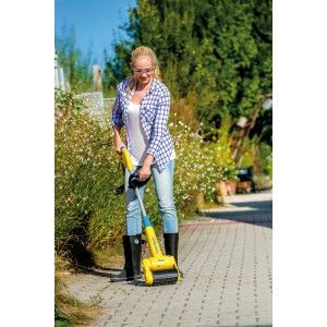 Frau nutzt Gloria Steinbürste Medium zur Reinigung von Pflastersteinen.