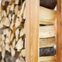 Westmann Kaminholzregal Michel XXL aus Lärchenholz, gefüllt mit Holzscheiten.