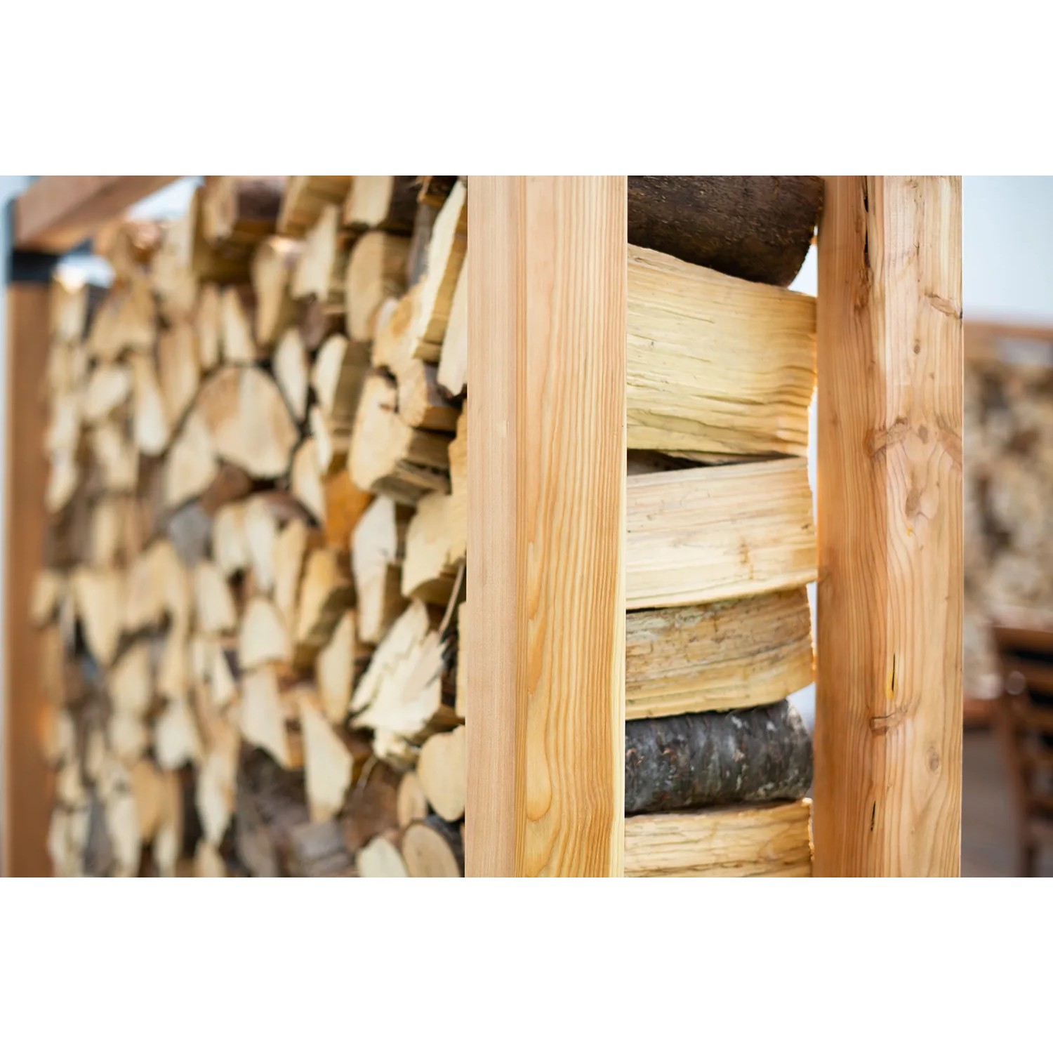 Westmann Kaminholzregal Michel XXL aus Lärchenholz, gefüllt mit Holzscheiten.