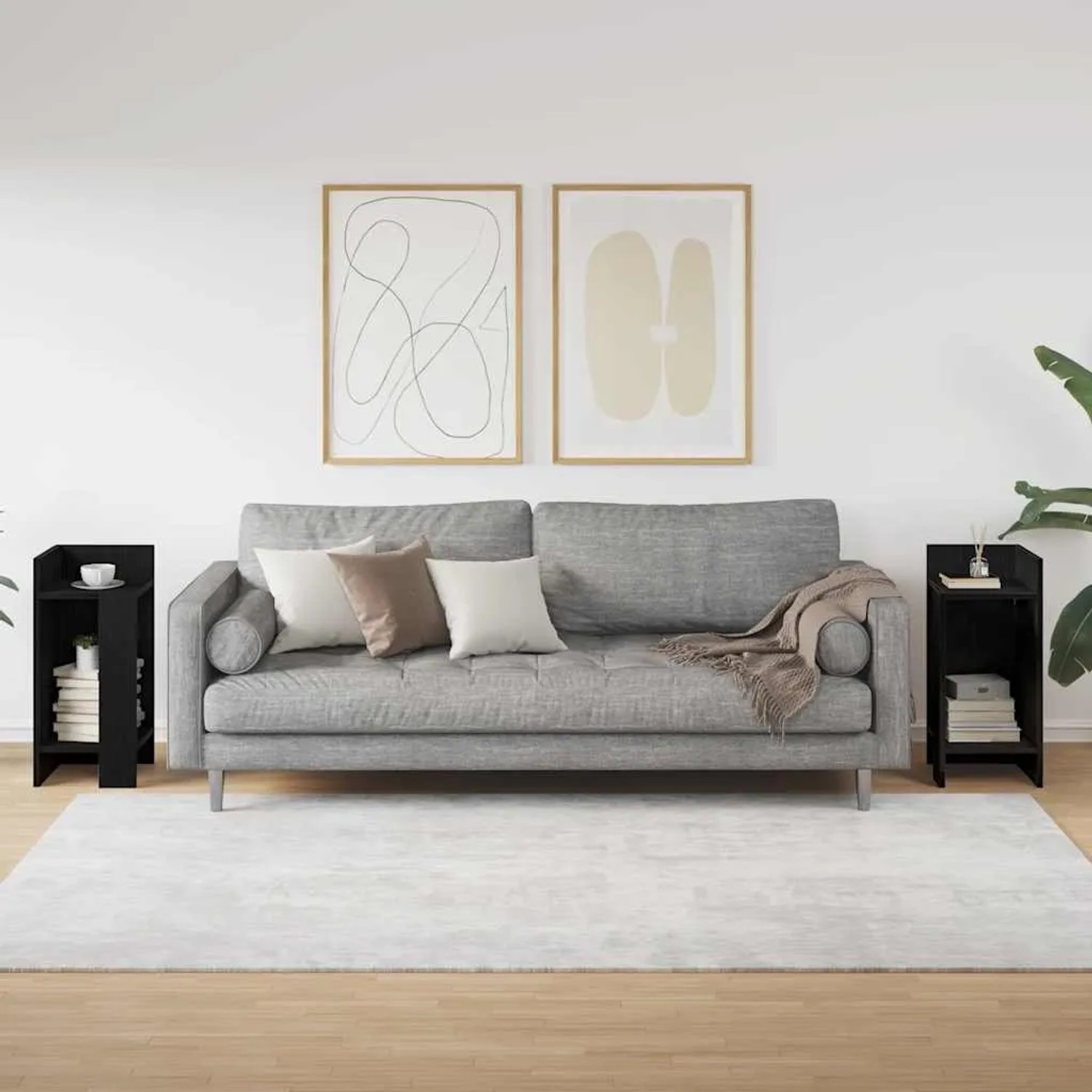 Zwei moderne schwarze Beistelltische aus Holzwerkstoff mit Ablagen neben einem Sofa im Wohnzimmer.