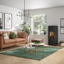 Schwarzer Justus Tova W+ Kaminofen (6 kW) im Wohnraum mit brennendem Feuer.