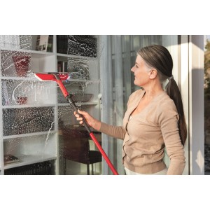 Frau reinigt Fenster mit Vileda Profi-Fensterwischer-Set mit Stiel.