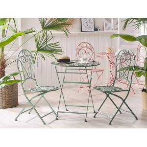 Hellgrüner, runder Beliani Gartentisch TRENTO mit filigranem Design und passenden Stühlen.