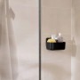 Schwarzer Tesa Lavaa Duschkorb Small an Wand mit Duschutensilien.