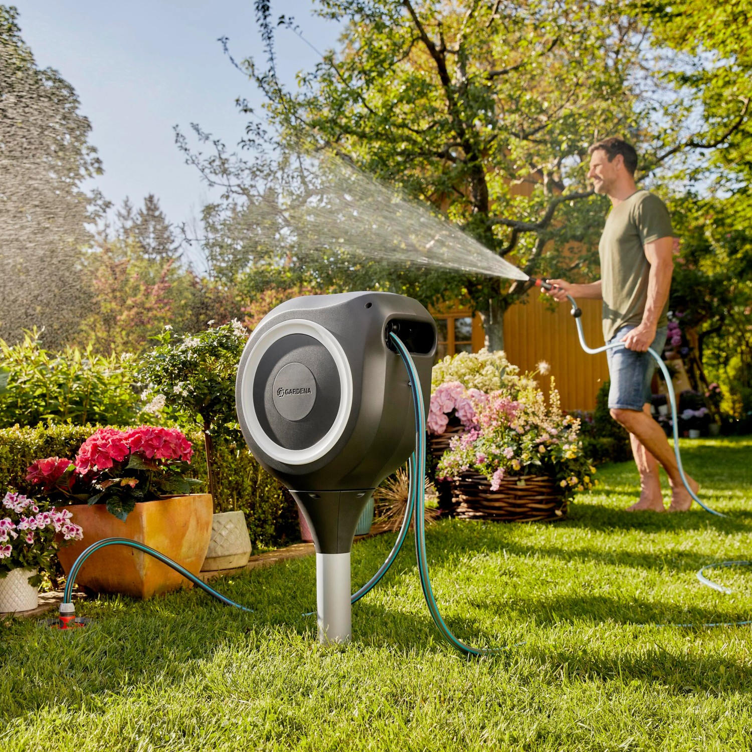 Gardena RollUp M Gartenschlauchbox mit 20 m Schlauch im Garten beim Bewässern.