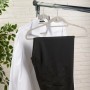 Zwei beflockte Kleiderbügel mit Hemd und Hose am Kleiderständer. Textile Aufbewahrung.