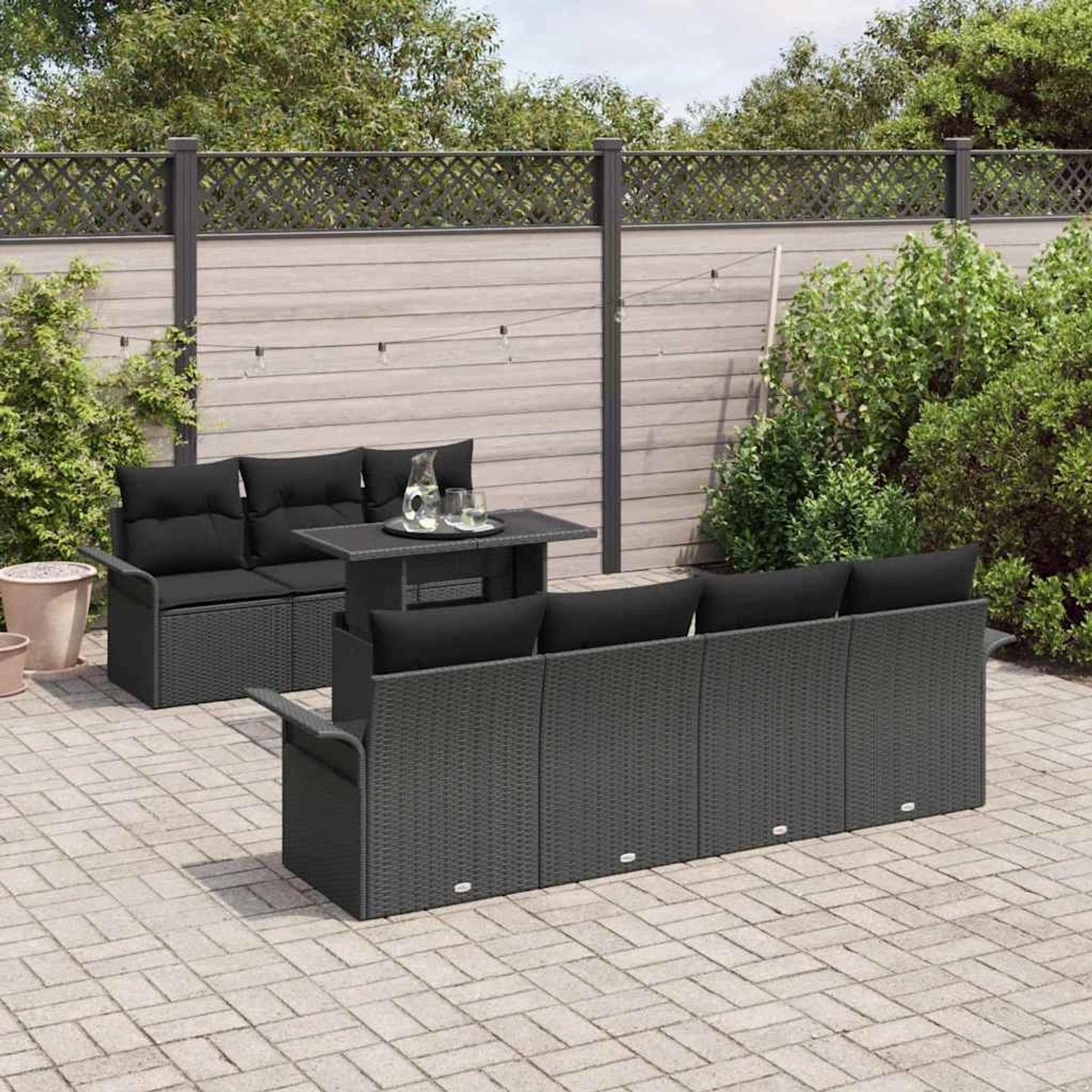 Schwarzes 8-teiliges Garten-Sofa-Set aus Poly Rattan mit Tisch und Kissen.