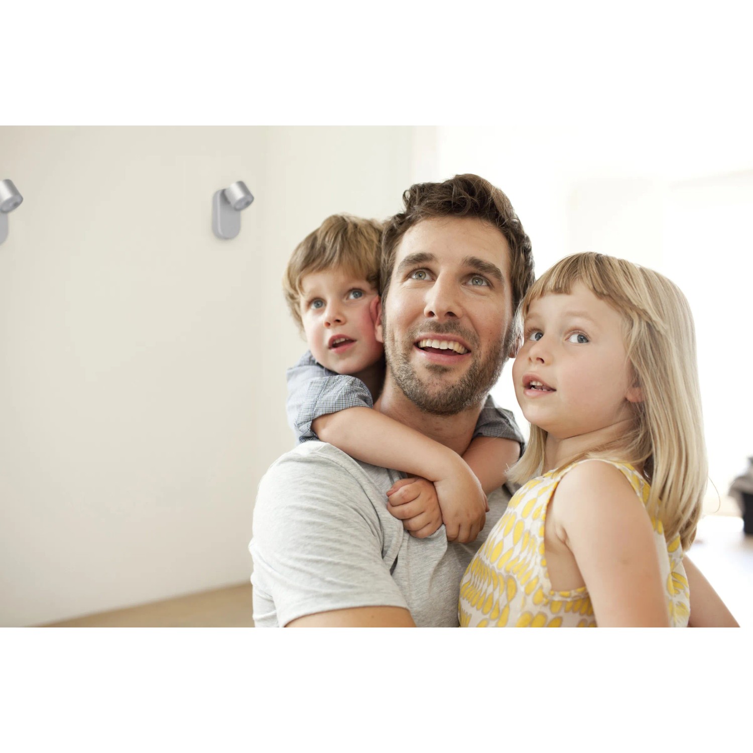 Philips LED-Spot Star Silber an Wand, Mann mit Kindern im Lichtkegel.