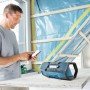 Bosch Professional Akku-Radio GPB 18V-2 C Solo mit Mann und Smartphone auf Baustelle.