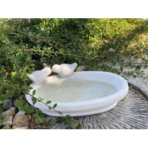 Weiße Orbis Vogeltränke aus Beton mit zwei Vogel-Figuren als Gartendeko.