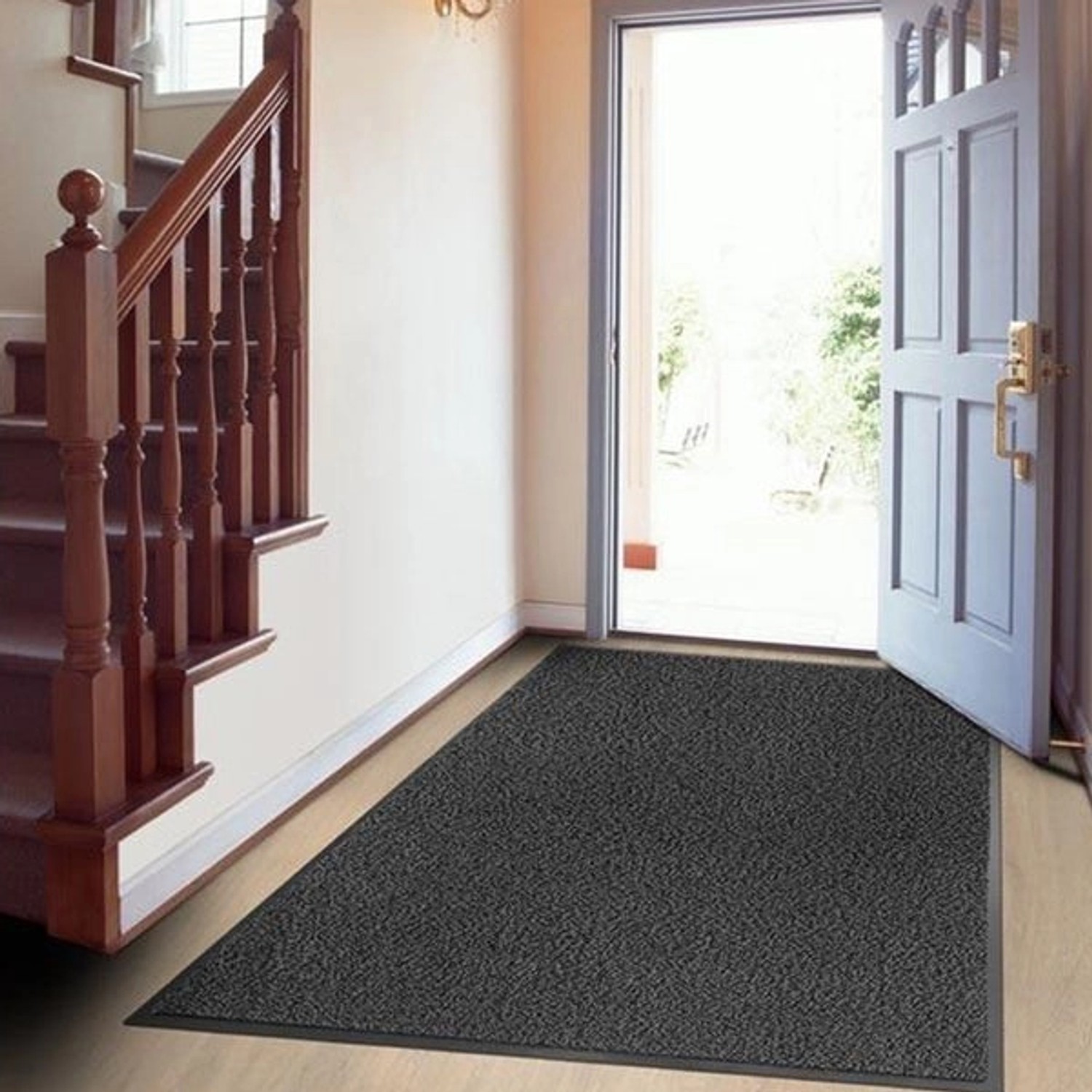 Anthrazitfarbene Karat Schmutzfangmatte SKY 200x200 cm im Eingangsbereich vor offener Tür.