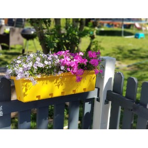 Gelber GreenLife Blumenkasten mit lila und weißen Blumen am Zaun. Komplett-Set für Garten und Balkon.
