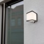 Anthrazitfarbene Lutec LED Solar Wandleuchte Doblo mit Bewegungsmelder an einer weißen Wand.