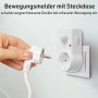 Weiße Oktaplex Sia Steckdose mit Bewegungsmelder. Hand steckt Stecker in Zwischenstecker für automatische Lichtsteuerung.