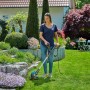 Frau trimmt Rasenkanten mit dem Gardena Elektro-Trimmer EasyCut 450/25 (blau/orange) in einem blühenden Garten.