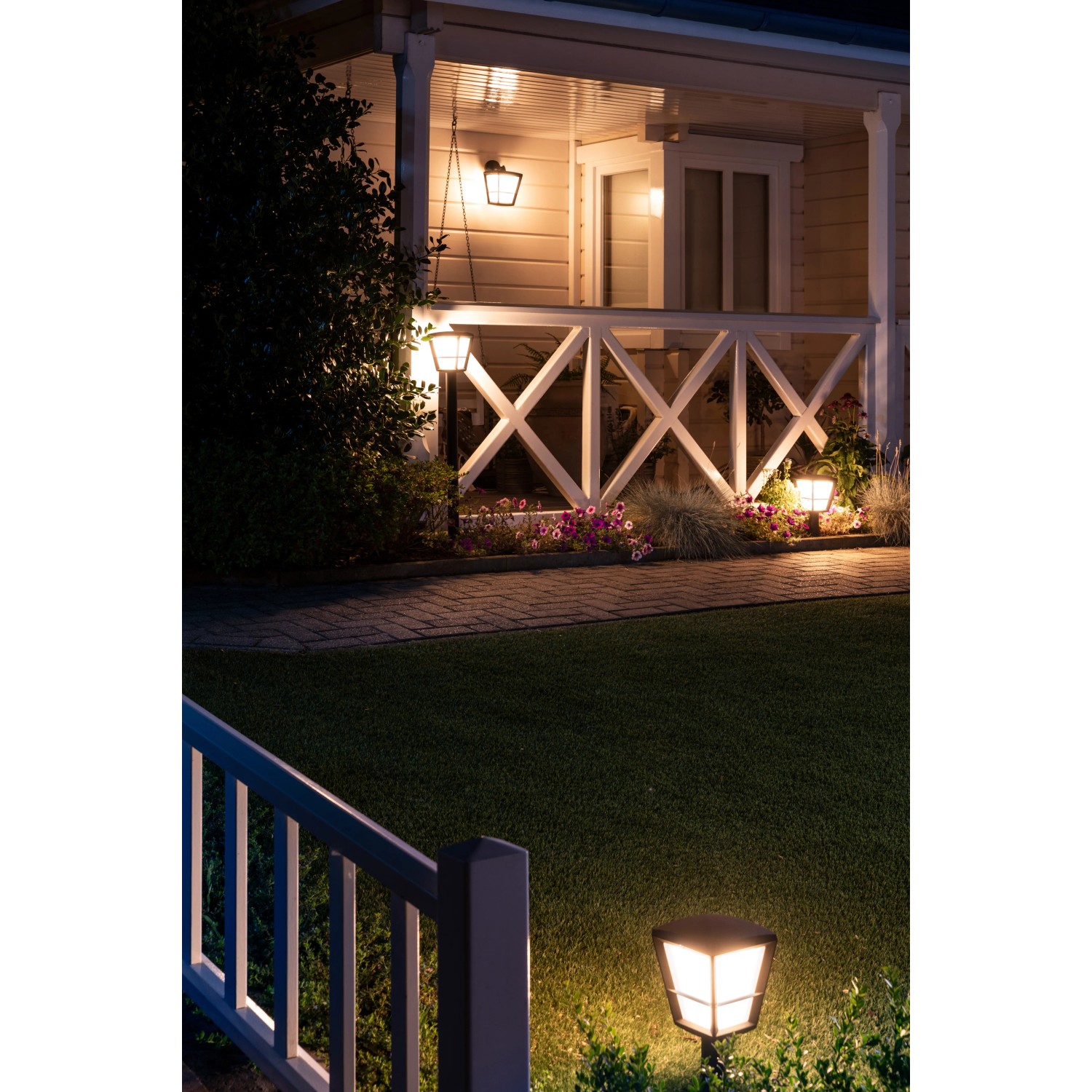 Philips Hue Econic LED-Wegeleuchten beleuchten Gartenweg und Terrasse in warmweißem Licht.
