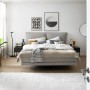 Schlafzimmer mit Bett, Teppich und Vorhängen vor Fenster. Dekorative Elemente im Raum.