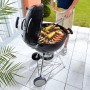Weber Holzkohle-Kugelgrill Classic Kettle 57 cm in Schwarz mit Grillgut.