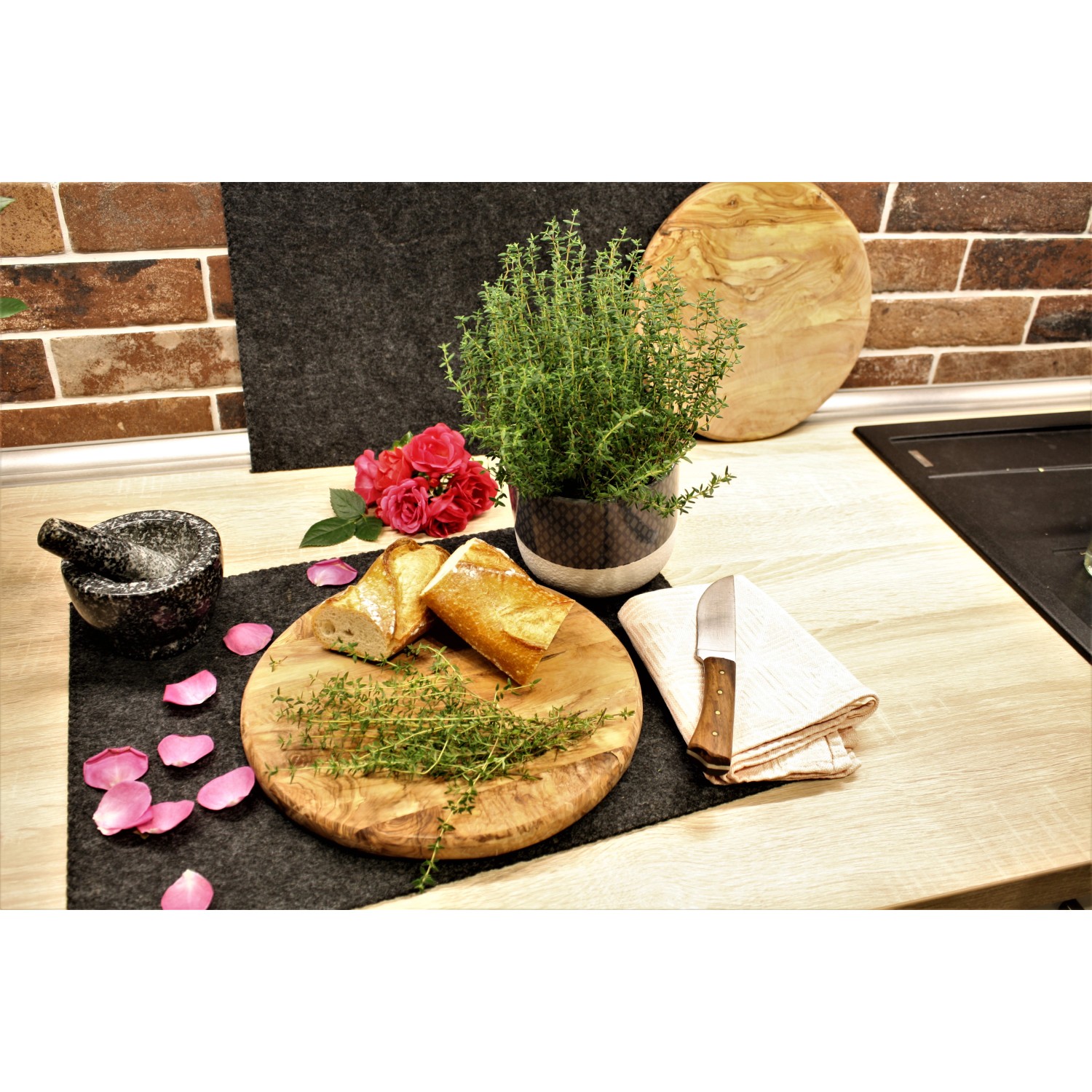 Blu Bio-Rosen-Thymian im Topf, mit Brot, Rosen und Mörser auf einem Küchentisch.