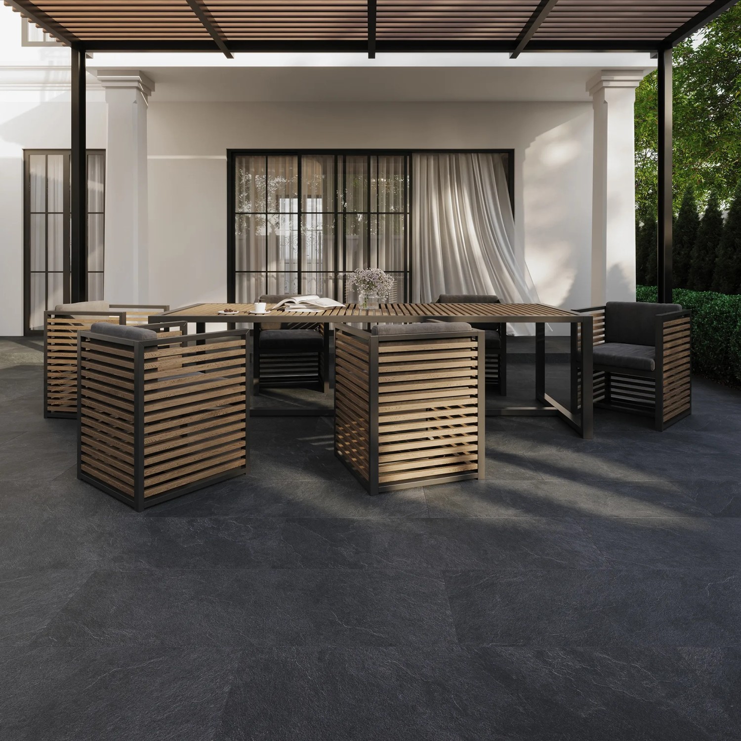 Verlegte, anthrazitfarbene Eurostone Terrassenplatten Piedra Scuro Feinsteinzeug 40x120 cm auf Terrasse mit Sitzgruppe.