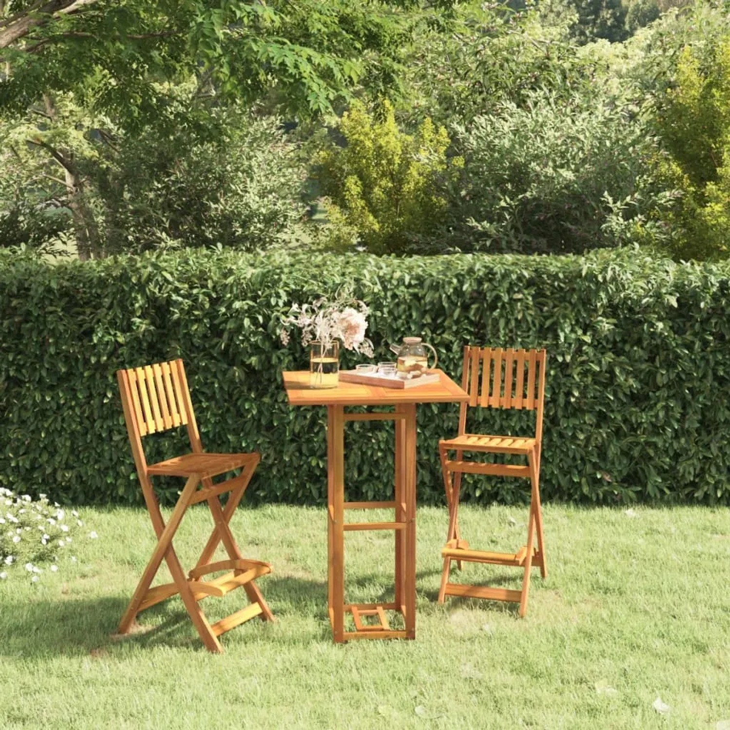 Bistrotisch aus Akazienholz mit zwei Stühlen im Garten.