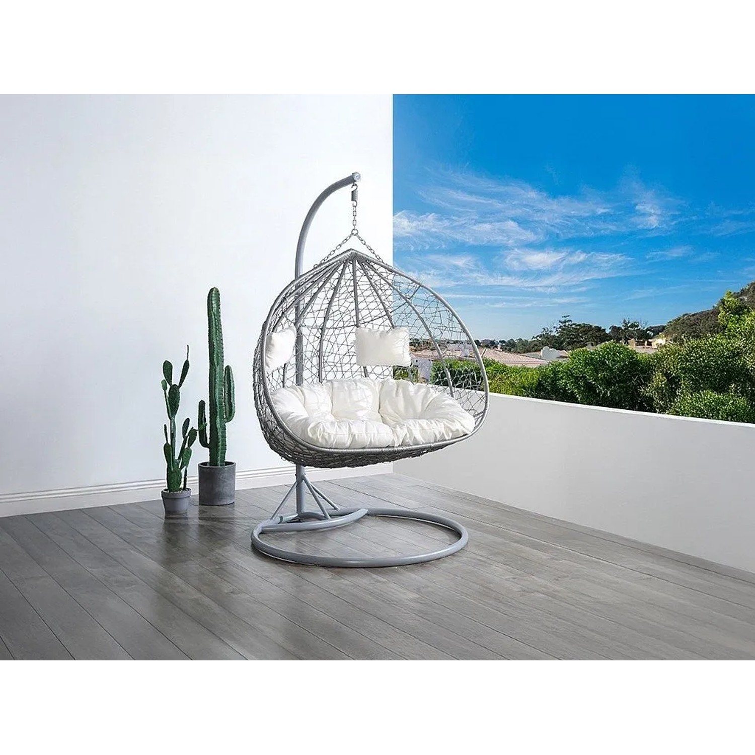 Grauer Polyrattan Hängesessel Cayambe mit weißen Kissen auf Balkon. 2-Sitzer Schwebesessel.
