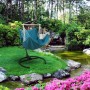 AMANKA XL Hängesessel petrolblau mit Gestell im Garten am Teich. Bequemer Schwebesessel für entspannte Stunden.