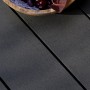 Anthrazitfarbene WPC Terrassendielen mit geriffelter Oberfläche und Dekoration.