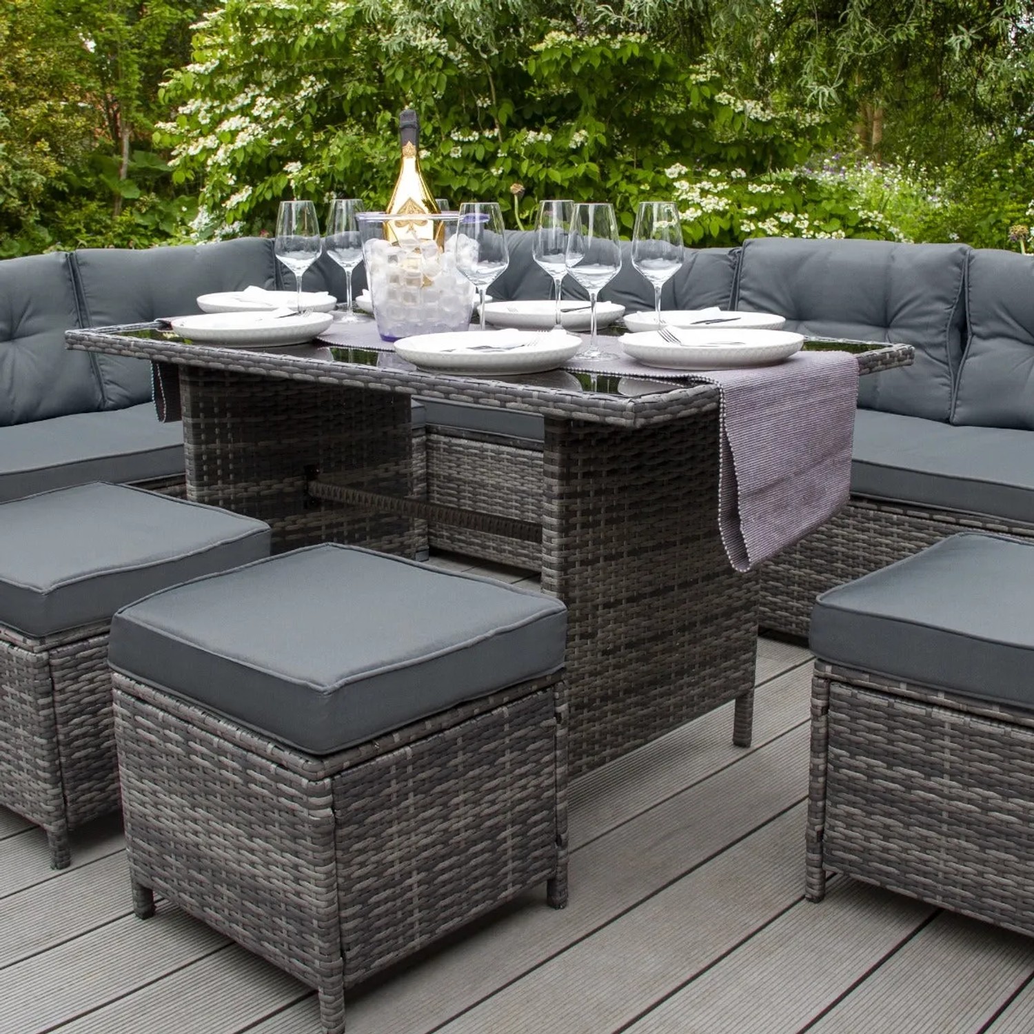 Graue Rattan Eckgarnitur von Monstershop mit Tisch, Hockern und Kissenbox für den Garten.