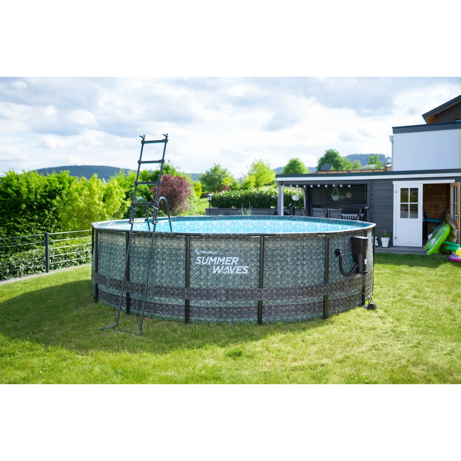 Runder Summer Waves Pool (488 cm) in Rattangrau mit Leiter im Garten.