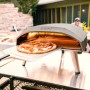 Ooni Koda 16 Gas Pizzaofen mit Pizza auf Pizzaschieber vor dem Ofen.