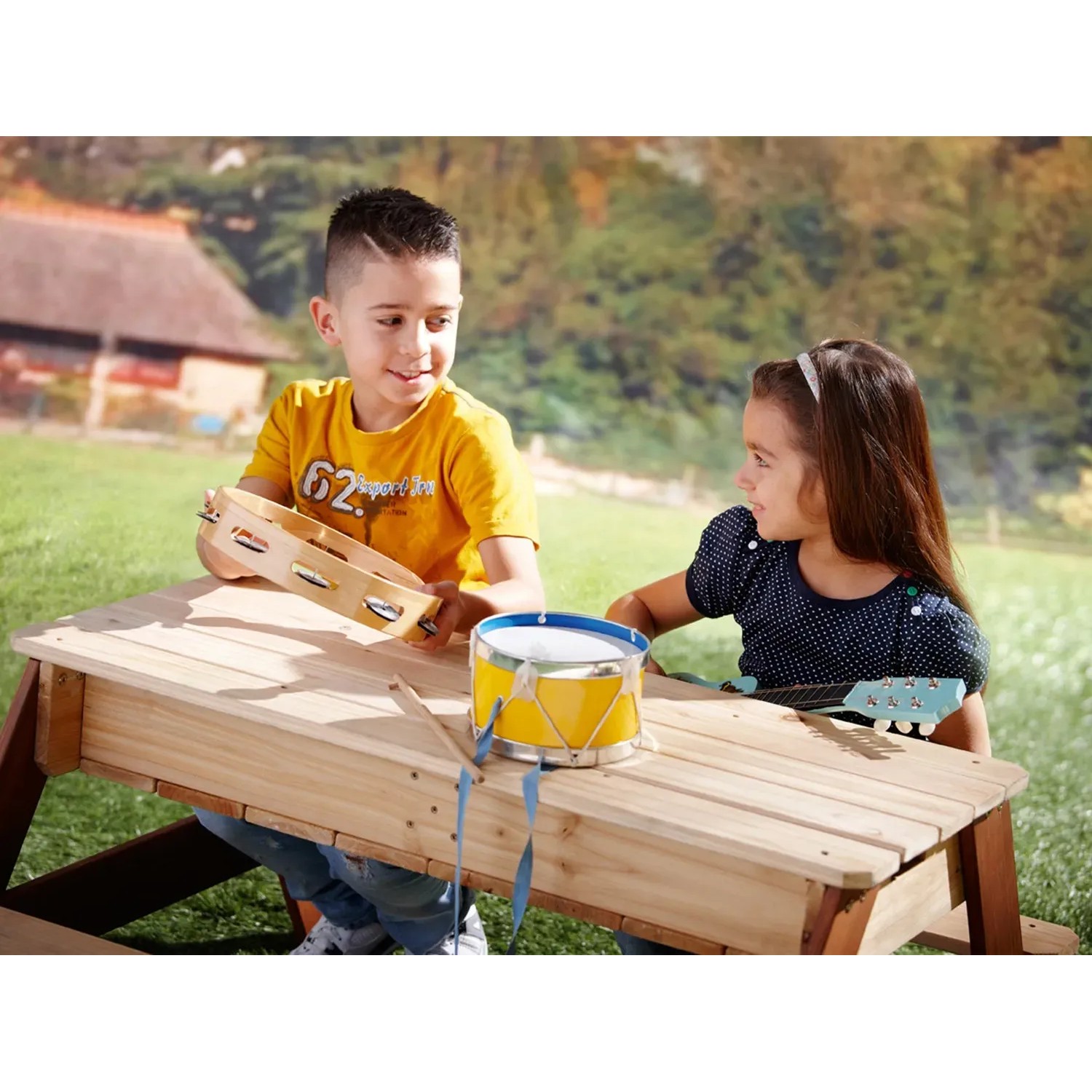 Axi Picknicktisch Nick mit Kindern beim Spielen mit Musikinstrumenten im Garten.