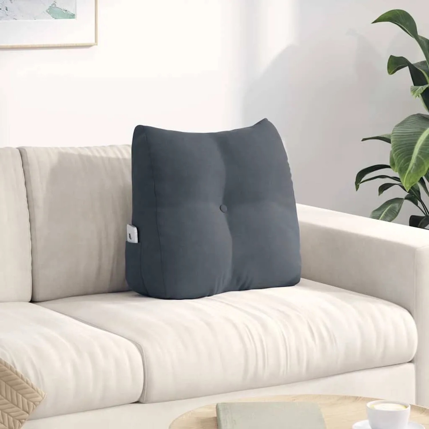 Dunkelgraues Samt-Rückenkissen mit Knöpfen auf Sofa. Ergonomisches Kissen mit Seitentasche für Komfort.