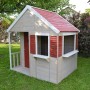 Wendi Toys Kinderspielhaus Krokodil mit rotem Dach, Veranda und Fenstern im Garten.